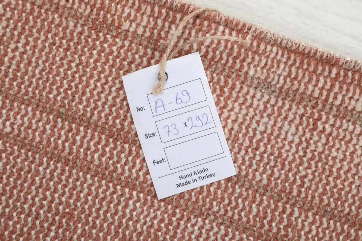Label showing the rug's dimensions in centimeters and origin: Hand Made, Made in Turkey
