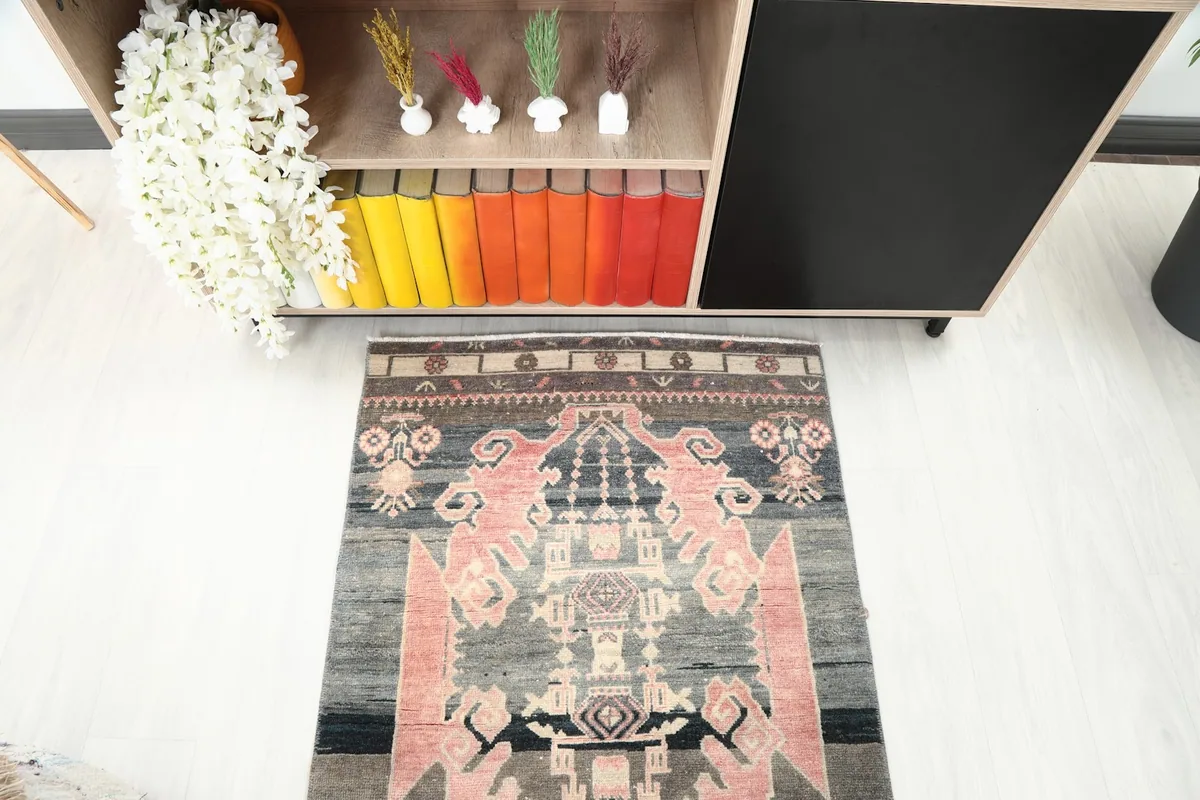 Top-down view of one end of the runner rug in a room, revealing the intricate border and main motifs.