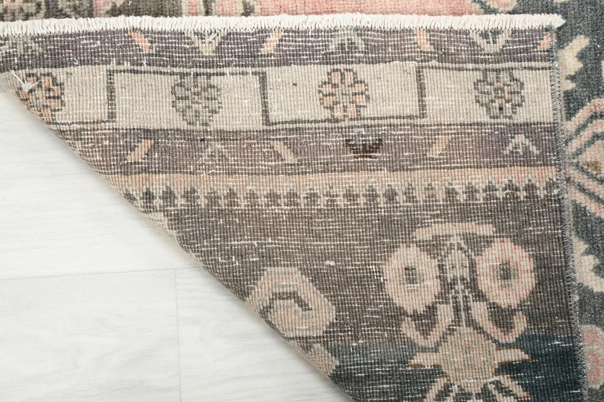 View of the back of the rug, illustrating the hand-knotted wool pile on a cotton foundation.