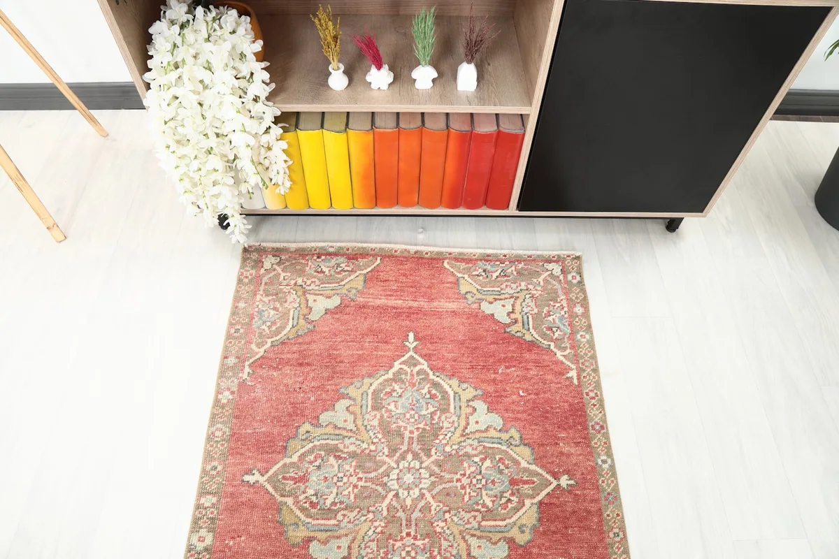 Top-down view of one end of the rust runner rug in a room setting