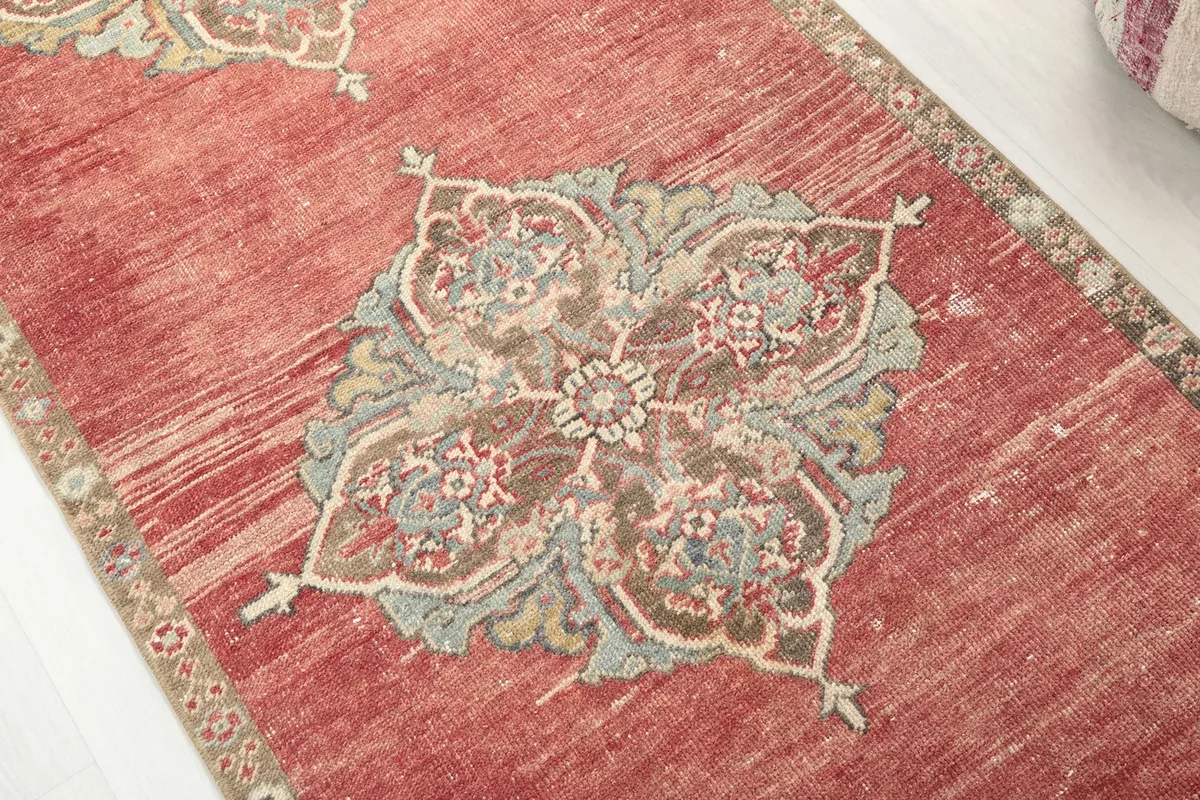 Detailed view of a central medallion on the rust runner rug, showing blue and beige tones