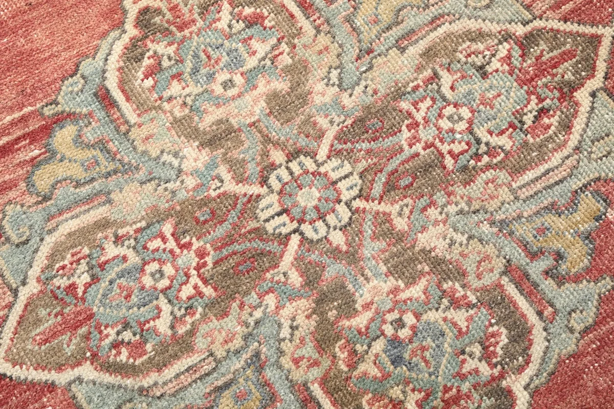 Close-up of the intricate patterns and colors within a medallion on the vintage rug