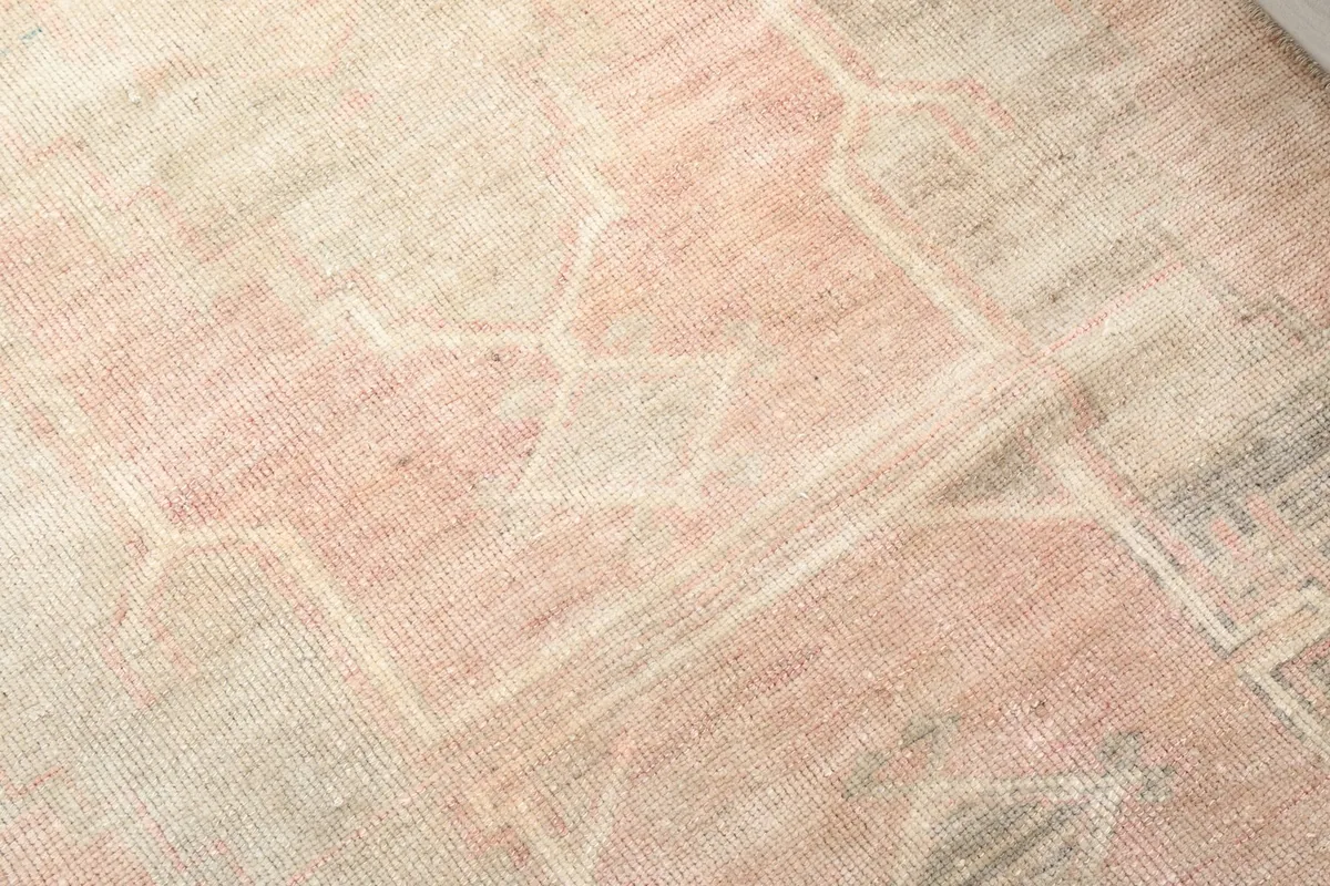 Texture detail of the low pile wool surface, revealing the hand-knotted construction and color variations.