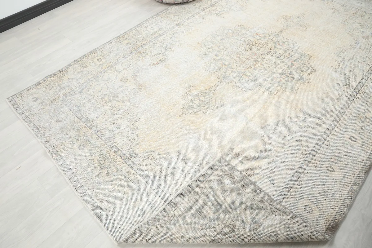 Corner of the rug folded back, revealing the wool pile and cotton foundation.