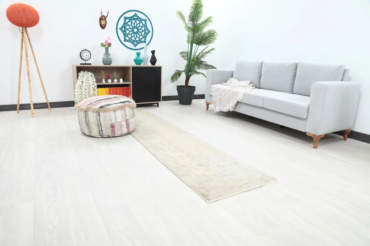 Angle view of the cream runner rug stretching across a room, complementing a light gray sofa