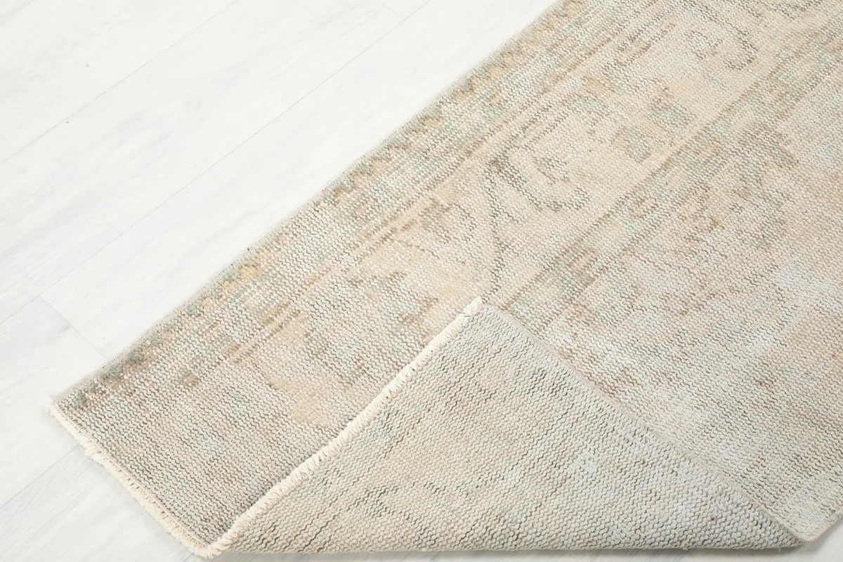 Corner of the runner rug folded back, showing the back and front texture