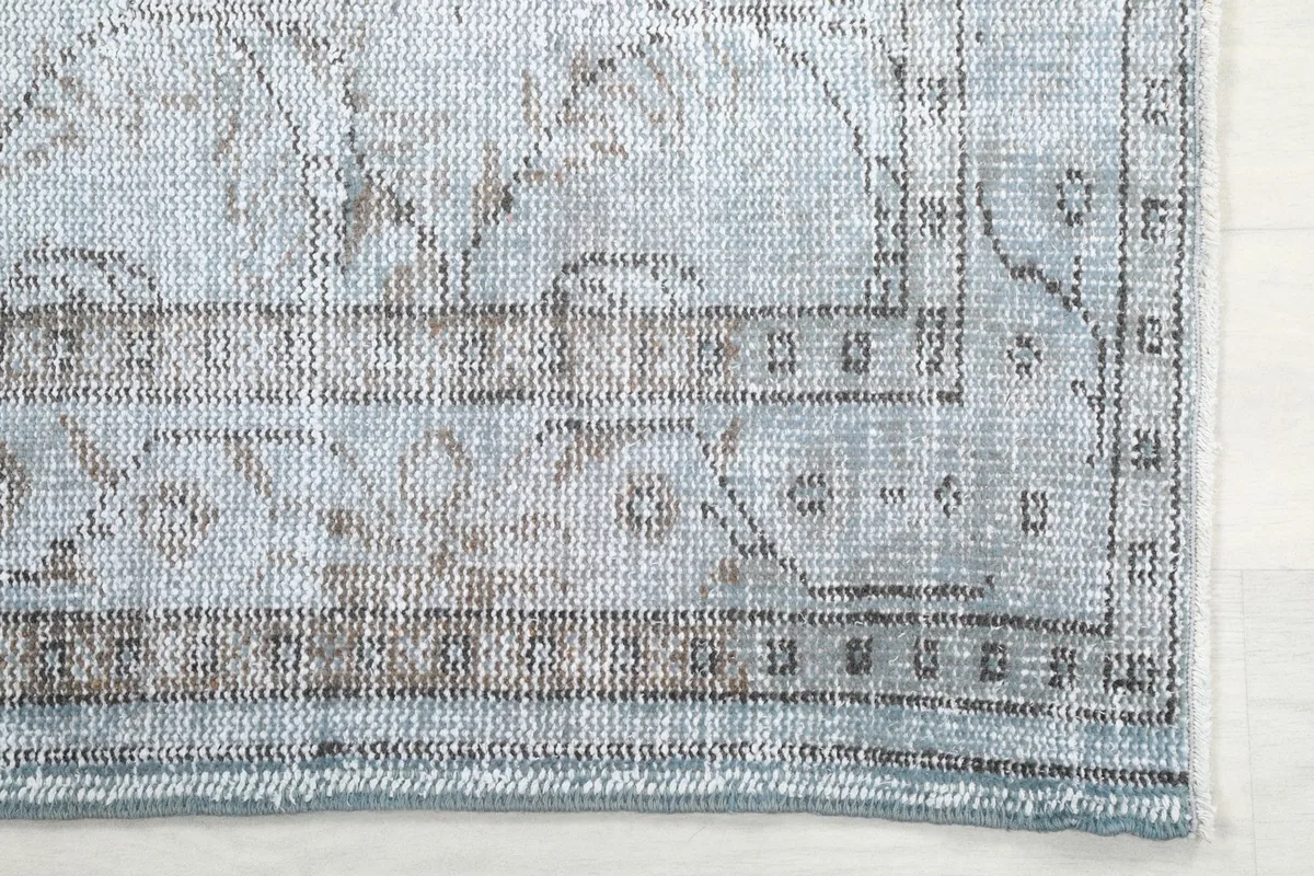 Detailed view of the corner and border design with blue, gray, and tan tones