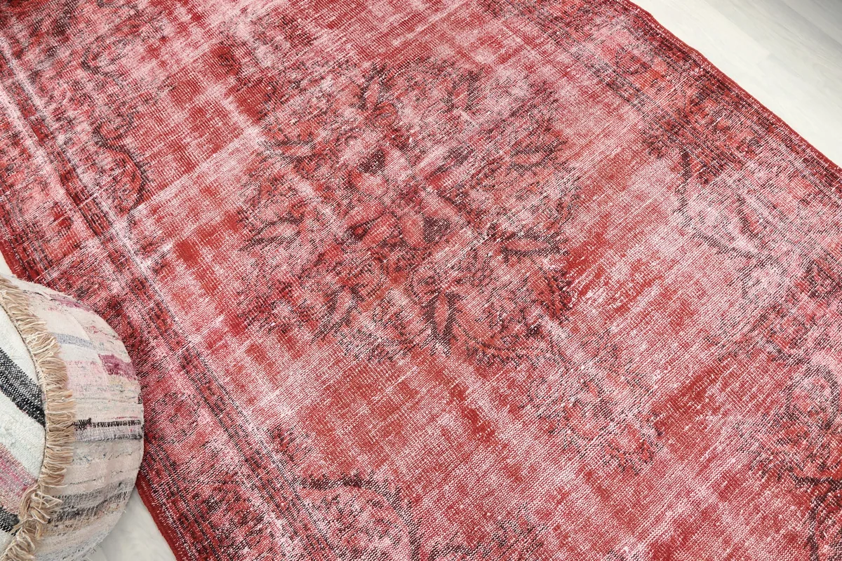 Angle view highlighting the worn red pile and charcoal design elements
