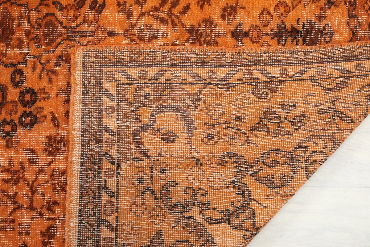 Close-up of the rug's corner showing the hand-knotted construction from the back.