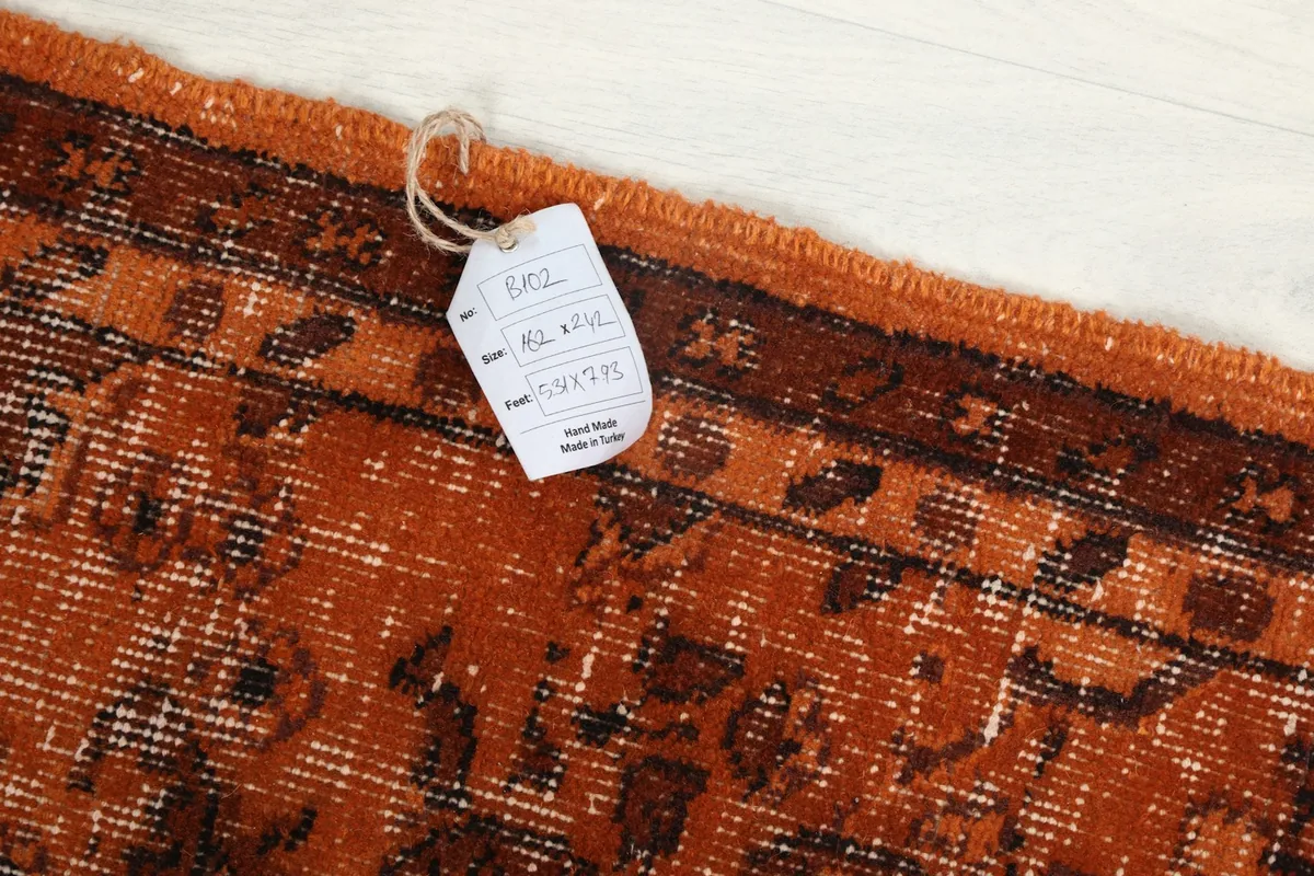 Close-up of the rug's edge with the product tag showing size and origin details.