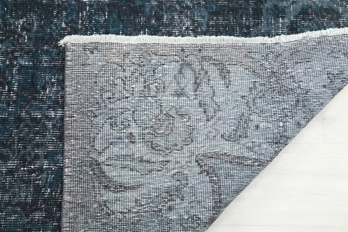 Close-up of the rug's back, showing the detailed weave of the cotton foundation and knotting.