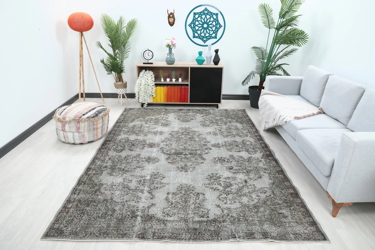 Vintage gray area rug in a modern living room setting with a light gray sofa and wooden floor