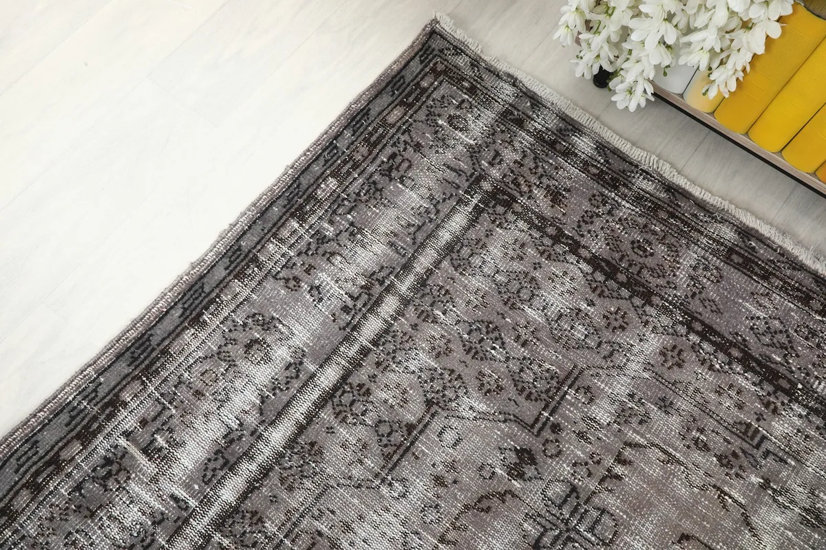 Corner view of the vintage rug highlighting the intricate border and field patterns