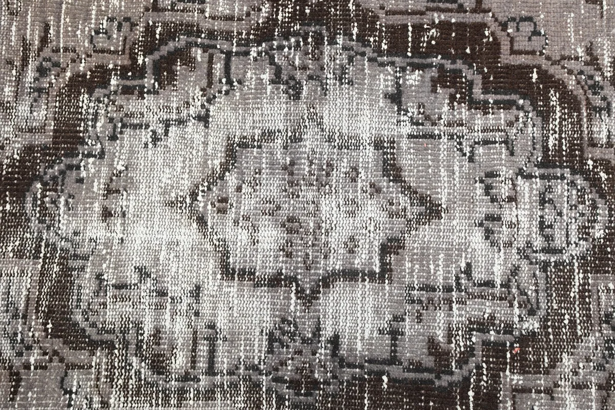 Tight detail of the central charcoal medallion and surrounding gray wool pile