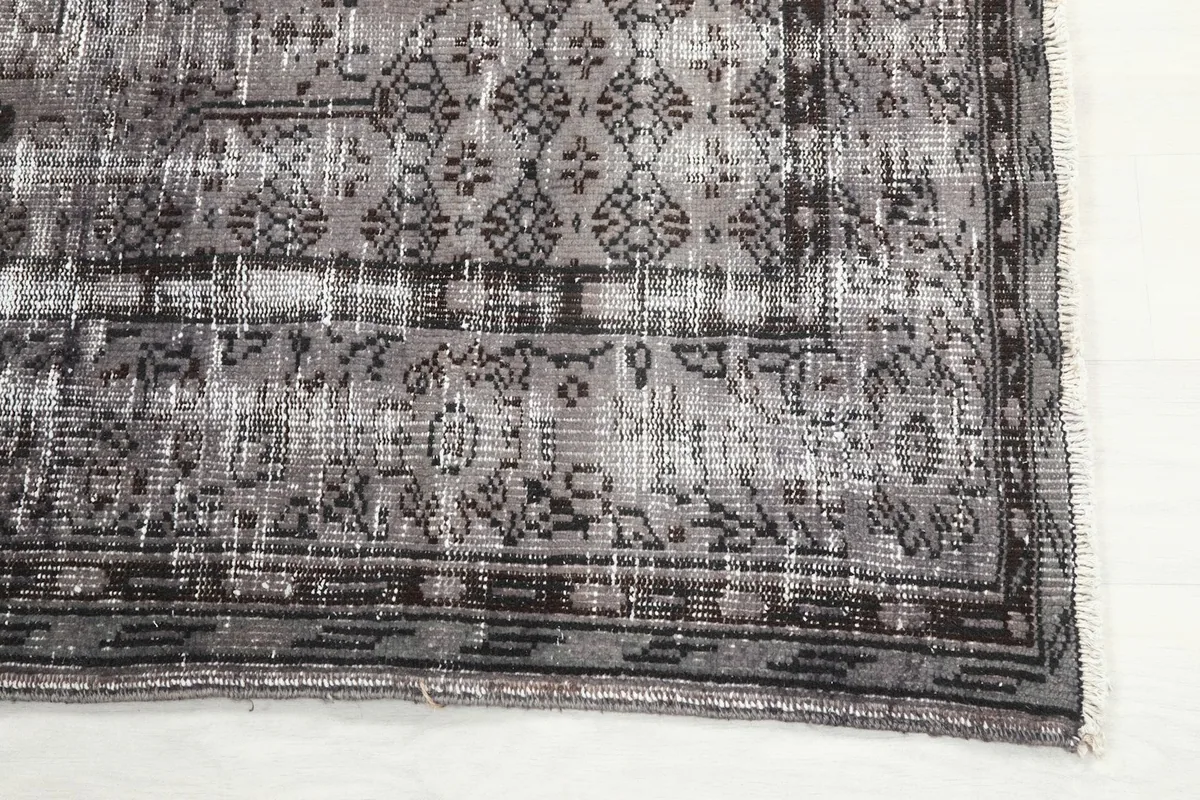 Detail of the outer border design and corner of the gray and charcoal area rug