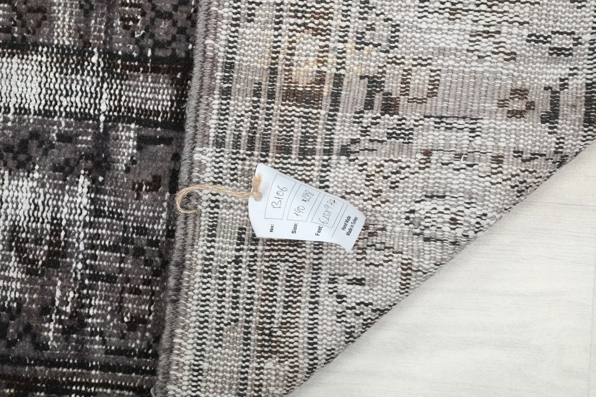 Close-up of the rug's tag with dimensions (190 x 298 cm) and material details
