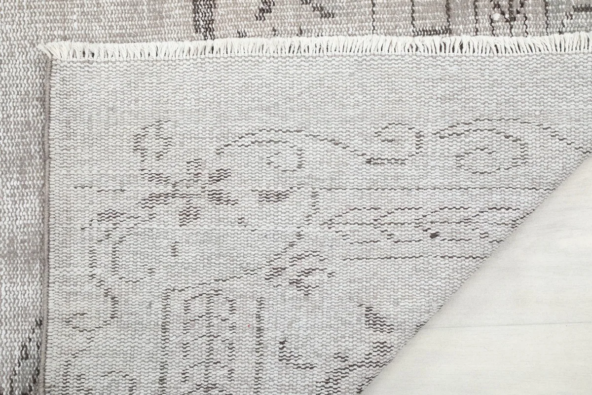 Close-up of the rug's back, showing the hand-knotted wool pile on cotton foundation