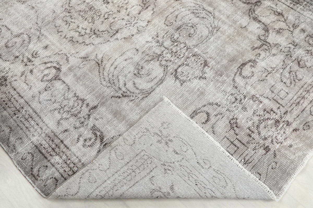 Folded corner of the rug revealing the cotton foundation and reverse side pattern