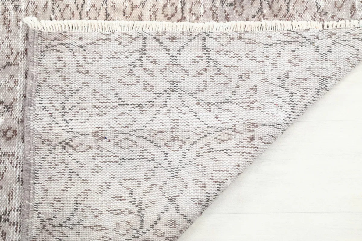 Underside of the rug, showing the cotton foundation and the reverse of the hand-knotted wool pile.