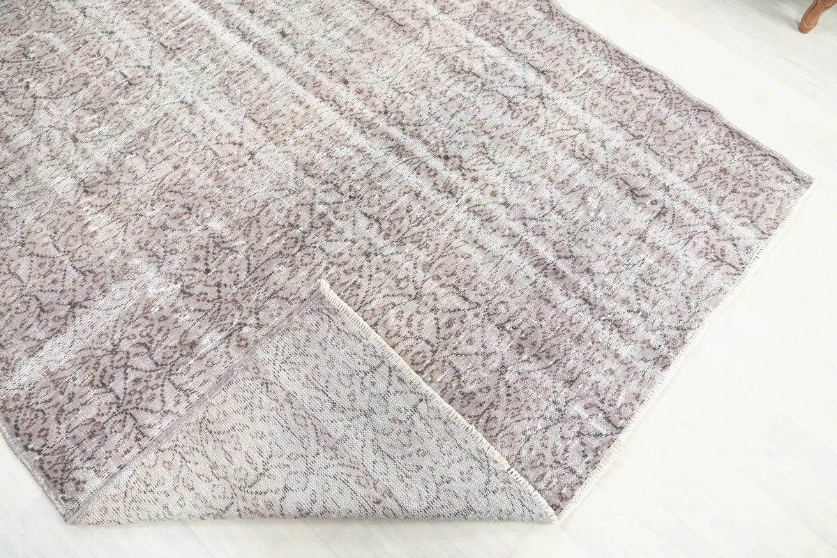 Corner of the rug folded back to reveal the cotton foundation and the reverse side of the knotting.
