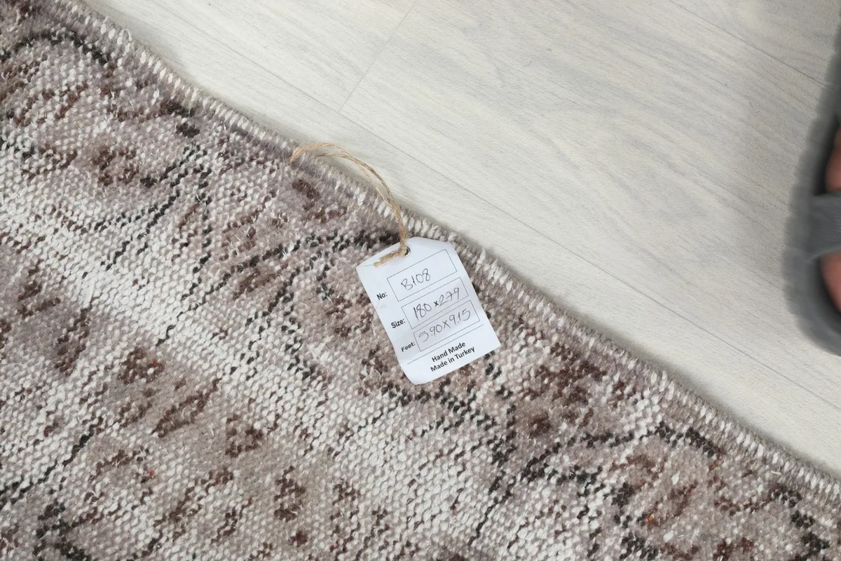 Close-up of the rug's corner with the product tag, showing details like material and origin.