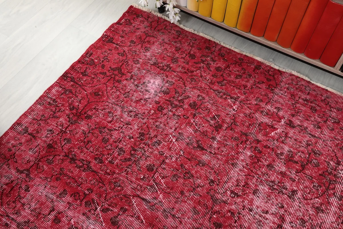 Corner view of the vintage rose rug, highlighting its faded areas and natural patina.