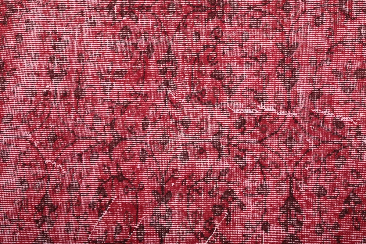 Close-up of the wool pile, revealing the subtle brown floral and geometric motifs within the rose field.