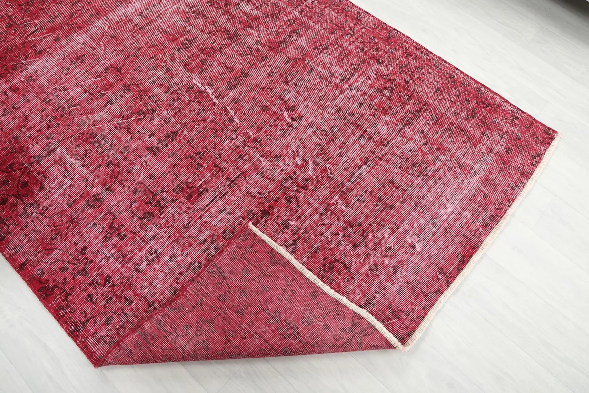 View of the rug's corner folded back, revealing the cotton foundation and reverse side.