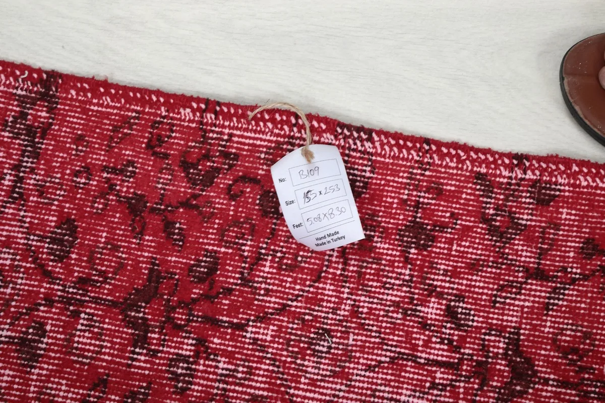Tag attached to the rug's edge, indicating product details and origin.