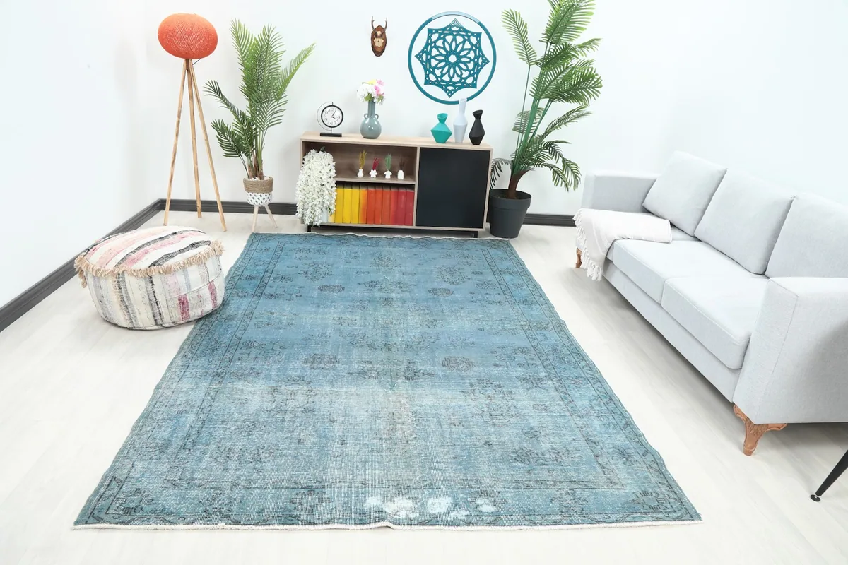 Vintage blue rug in a modern living room setting with a light gray sofa and wooden furniture