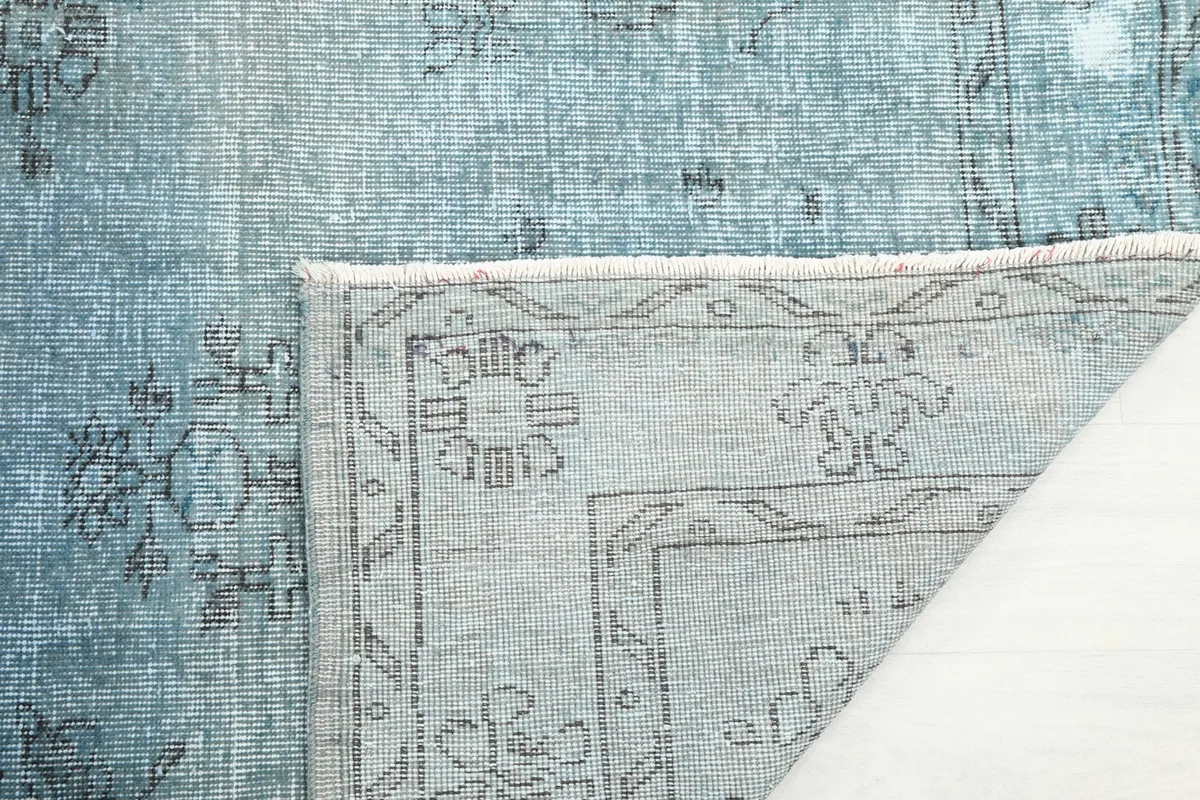 Close-up of the folded corner, revealing the knotting on the back and the texture of the foundation