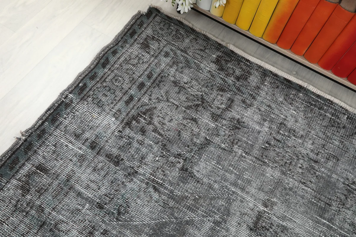 Angle view highlighting the rug's border and the subtle color variations in the gray field