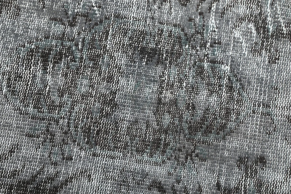 Extreme close-up of the low wool pile, revealing the knotting and distressed fibers