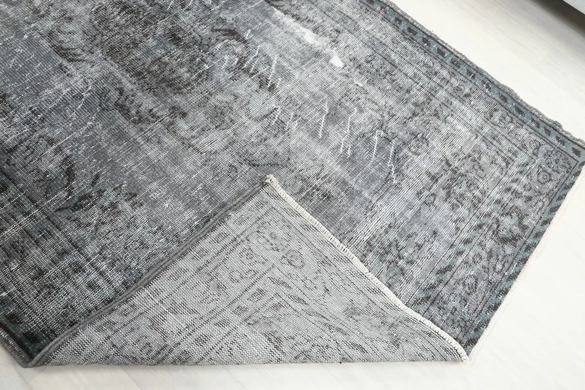 Folded corner of the rug, showing the back of the hand-knotted cotton foundation and wool pile