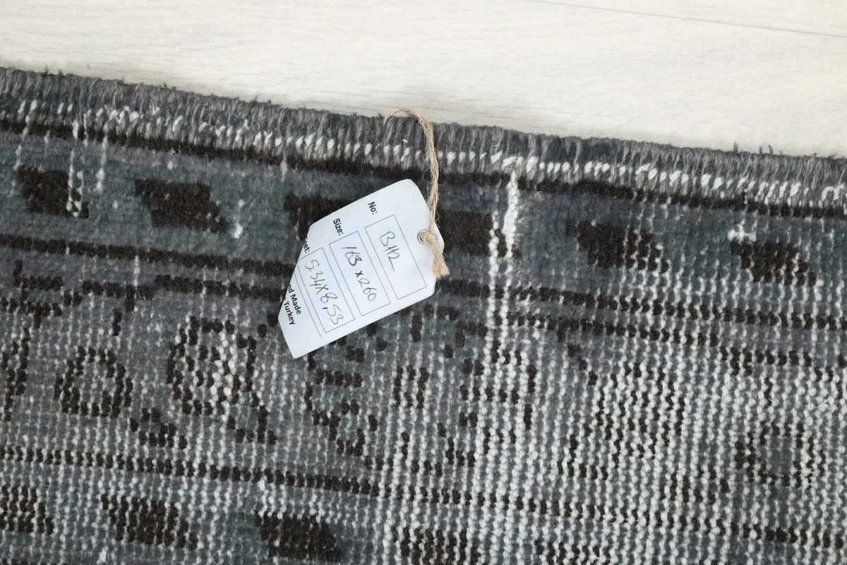 Close-up of the product tag attached to the rug, displaying size and origin information