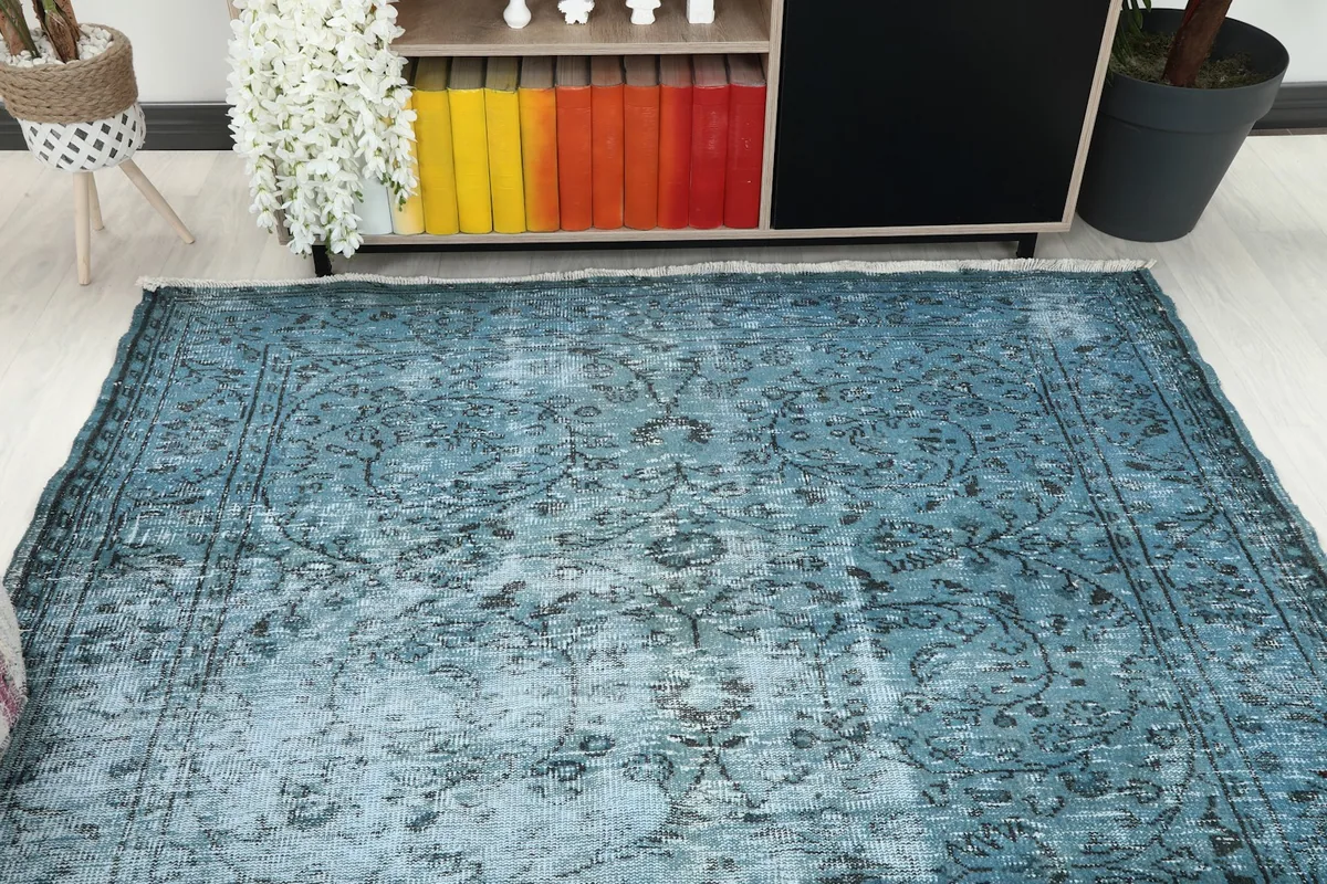 Overhead view of the faded blue rug in a room, showing its placement relative to furniture.