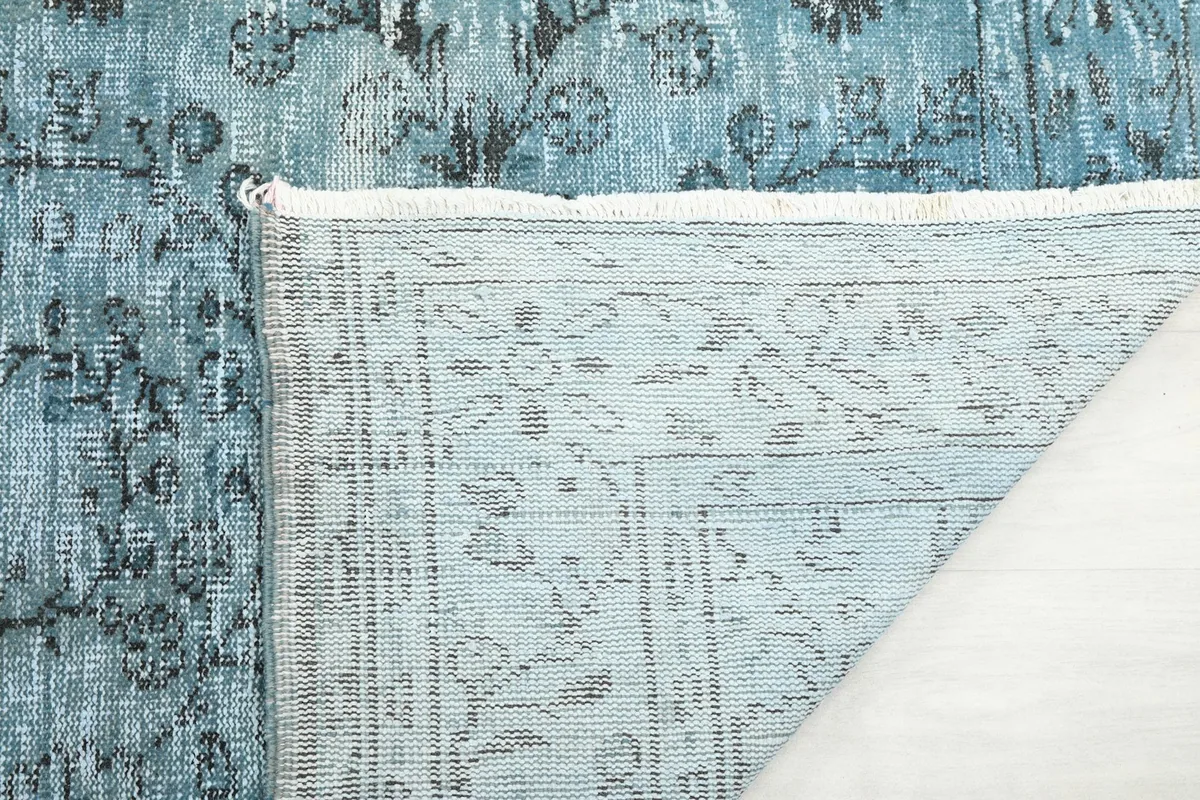 Close-up of the rug's back, showing the tight knotting of the wool pile on cotton foundation.