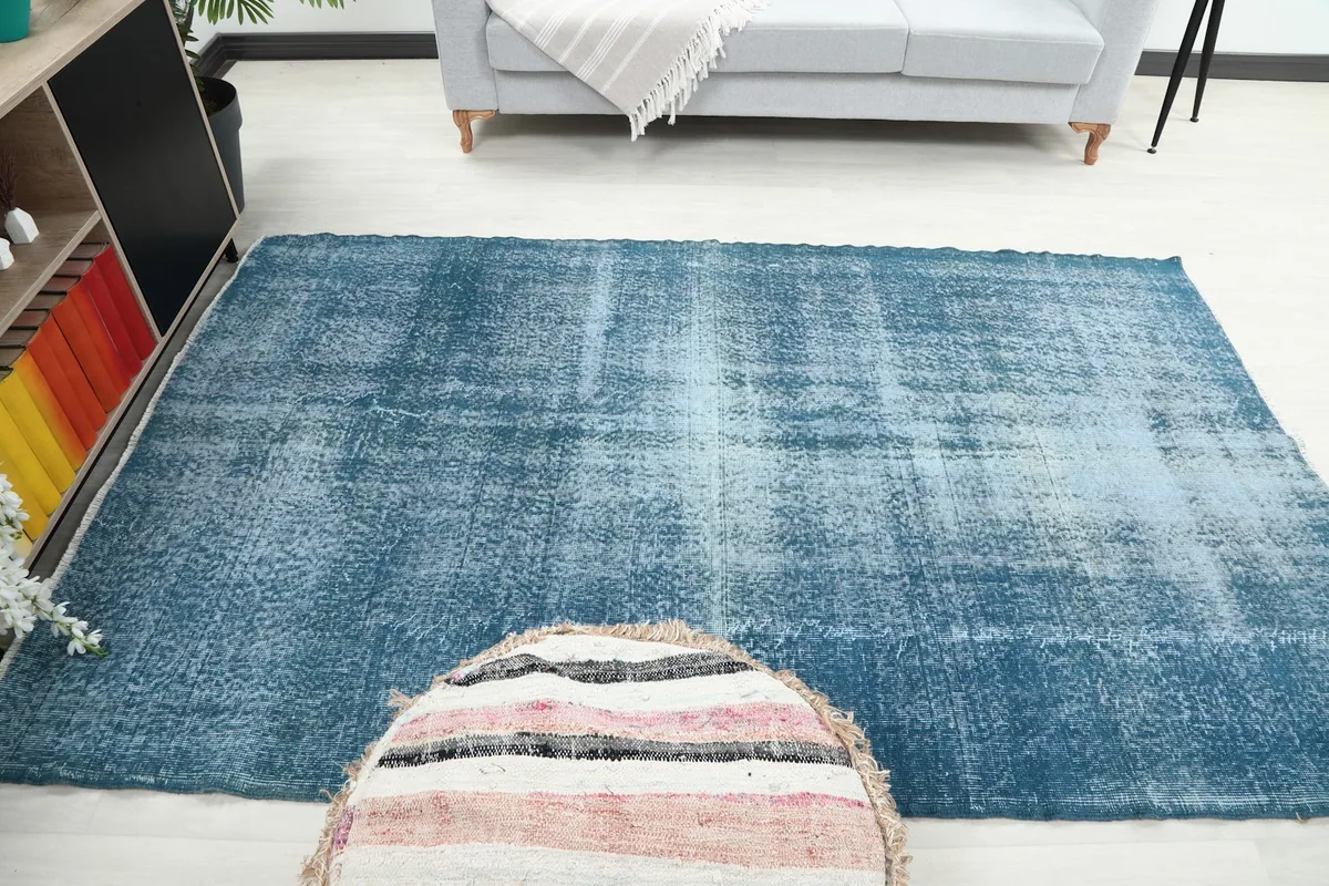 View of the blue area rug from the opposite side of the room, highlighting its overall presence.