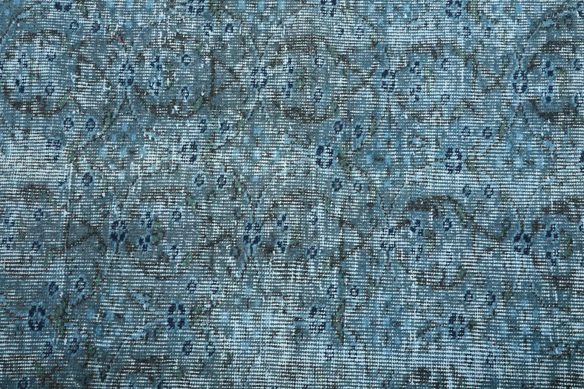 Macro view of the hand-knotted pile, revealing variations in blue and charcoal tones