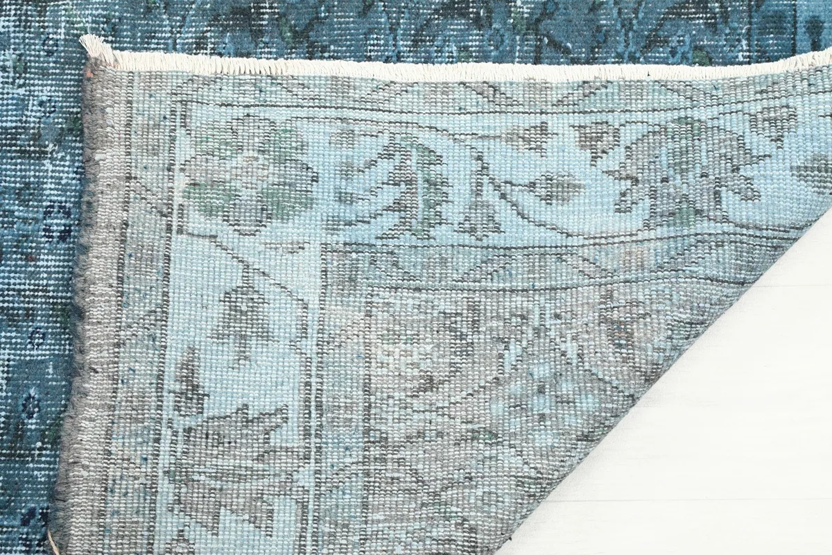 Close-up of the rug's underside, revealing the intricate knotting and fringe detail