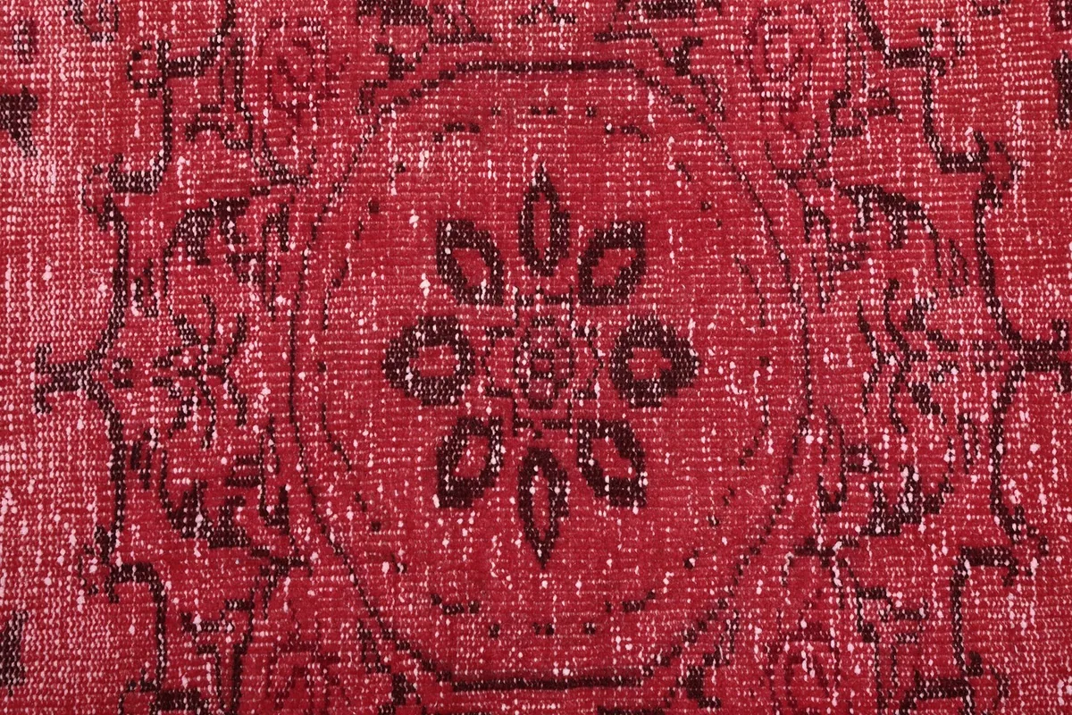 Detailed view of the hand-knotted texture and charcoal pattern on red field