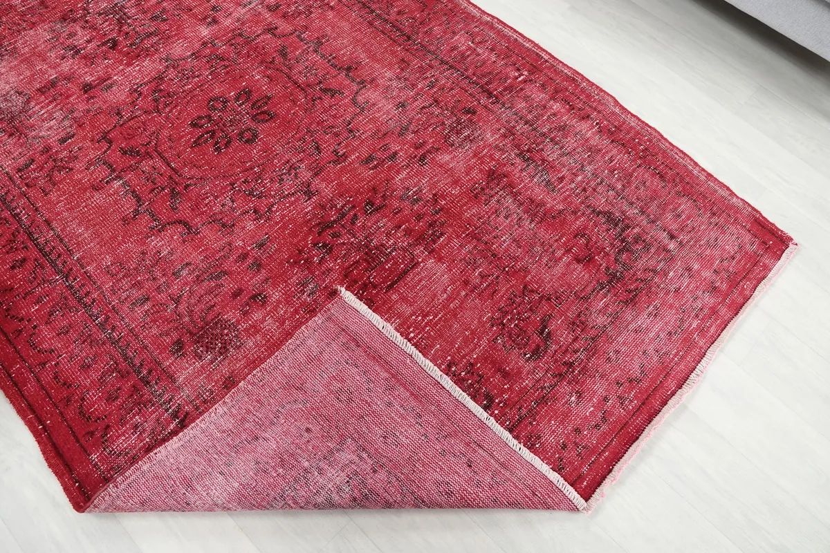 Corner of the rug folded back to show the wool pile and cotton foundation