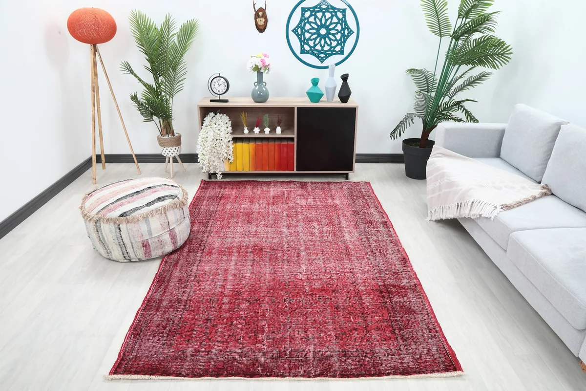 Rose vintage wool rug in a modern living room setting with a gray couch and decorative items.