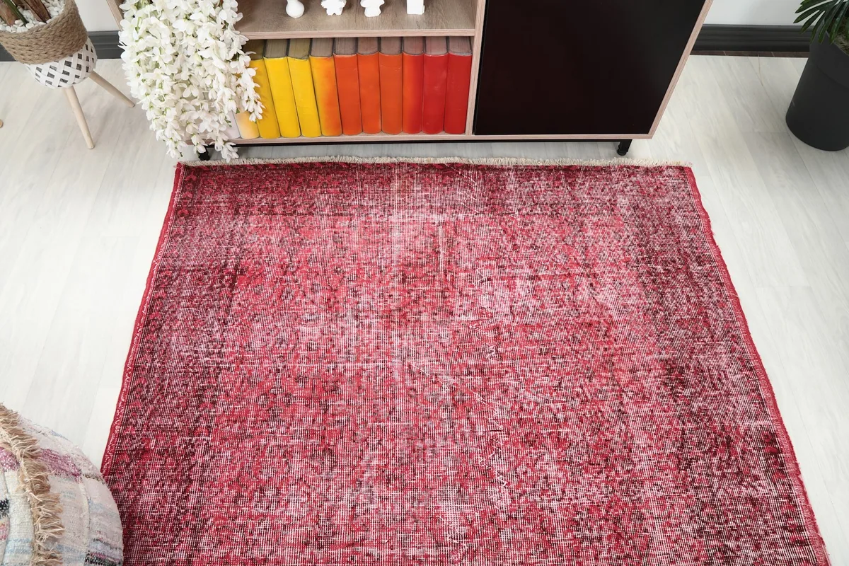 Overhead view of the rose vintage rug, showcasing its rectangular shape and overall distressed appearance.