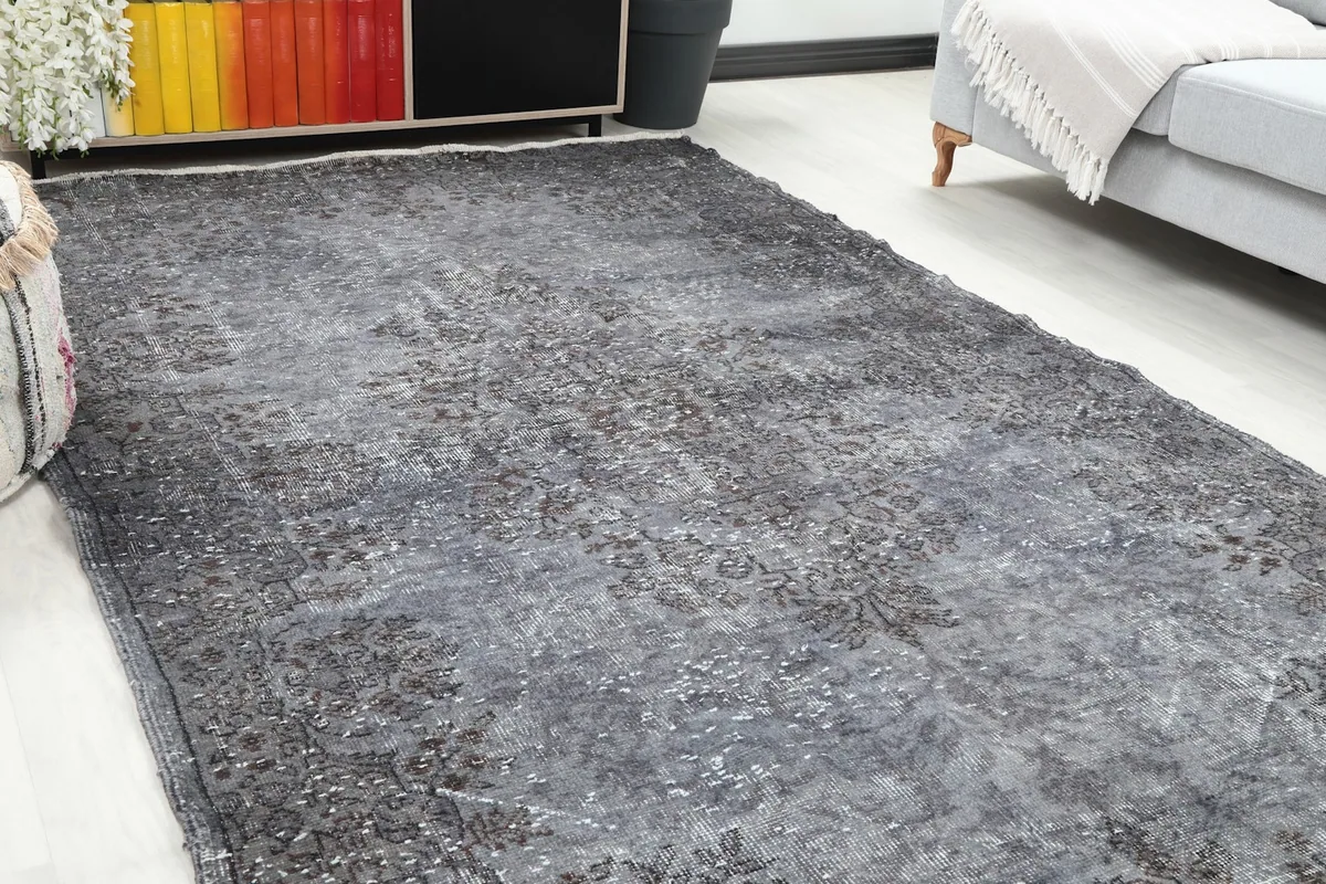 Close-up angle of the gray distressed rug, highlighting its faded floral motifs