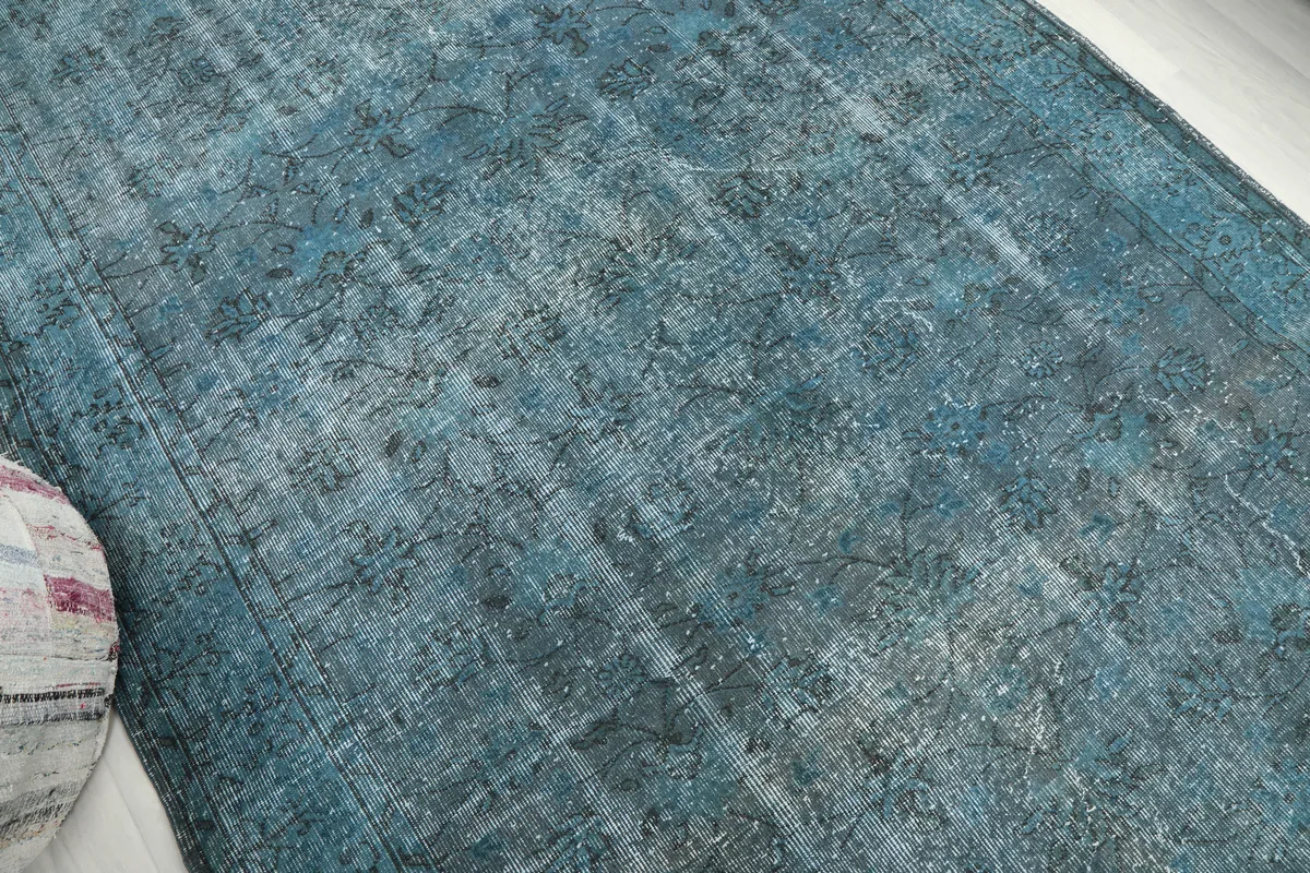 Another angle shot of the Blue Gray Faded Floral Anatolian Rug, emphasizing its distressed look and low pile.
