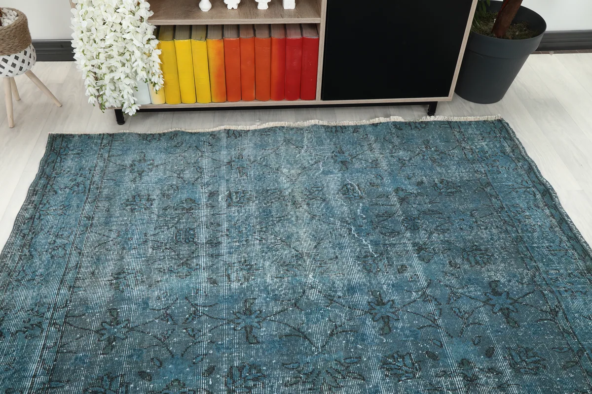 Overhead view of the Blue Gray Faded Floral Anatolian Rug in a room, showing its full rectangular shape and border.