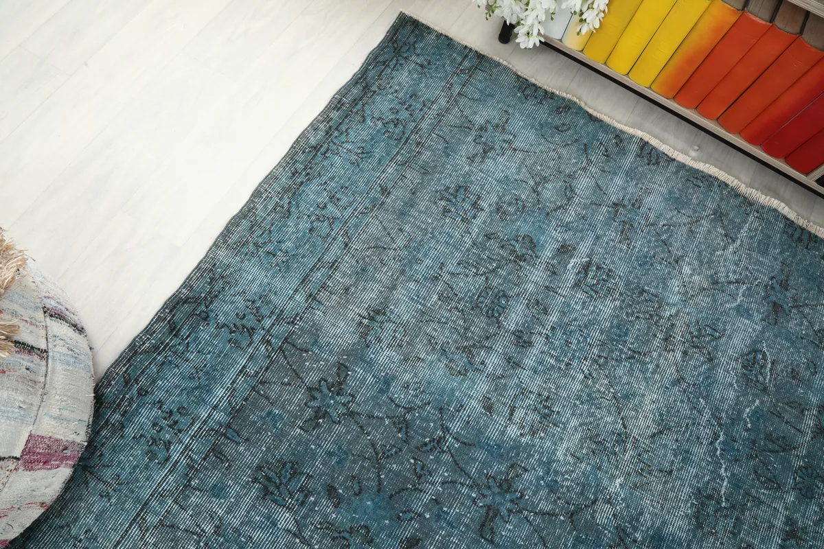 Corner view of the Blue Gray Faded Floral Anatolian Rug, illustrating how the colors blend into the room's light flooring.