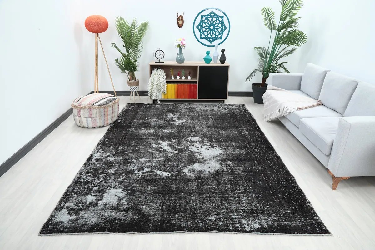 Charcoal and gray vintage rug shown in a living room setting with a light couch