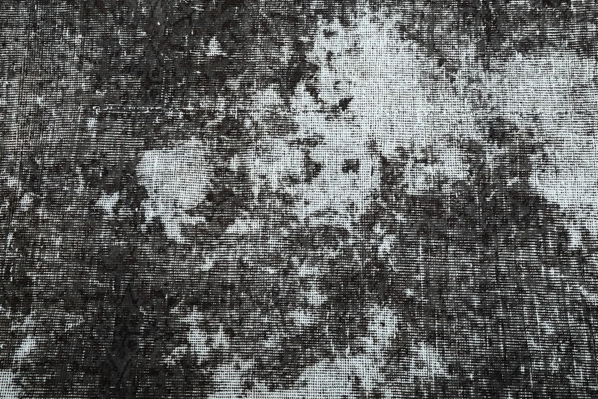 Detailed view of the charcoal and gray wool pile, showing wear and fading